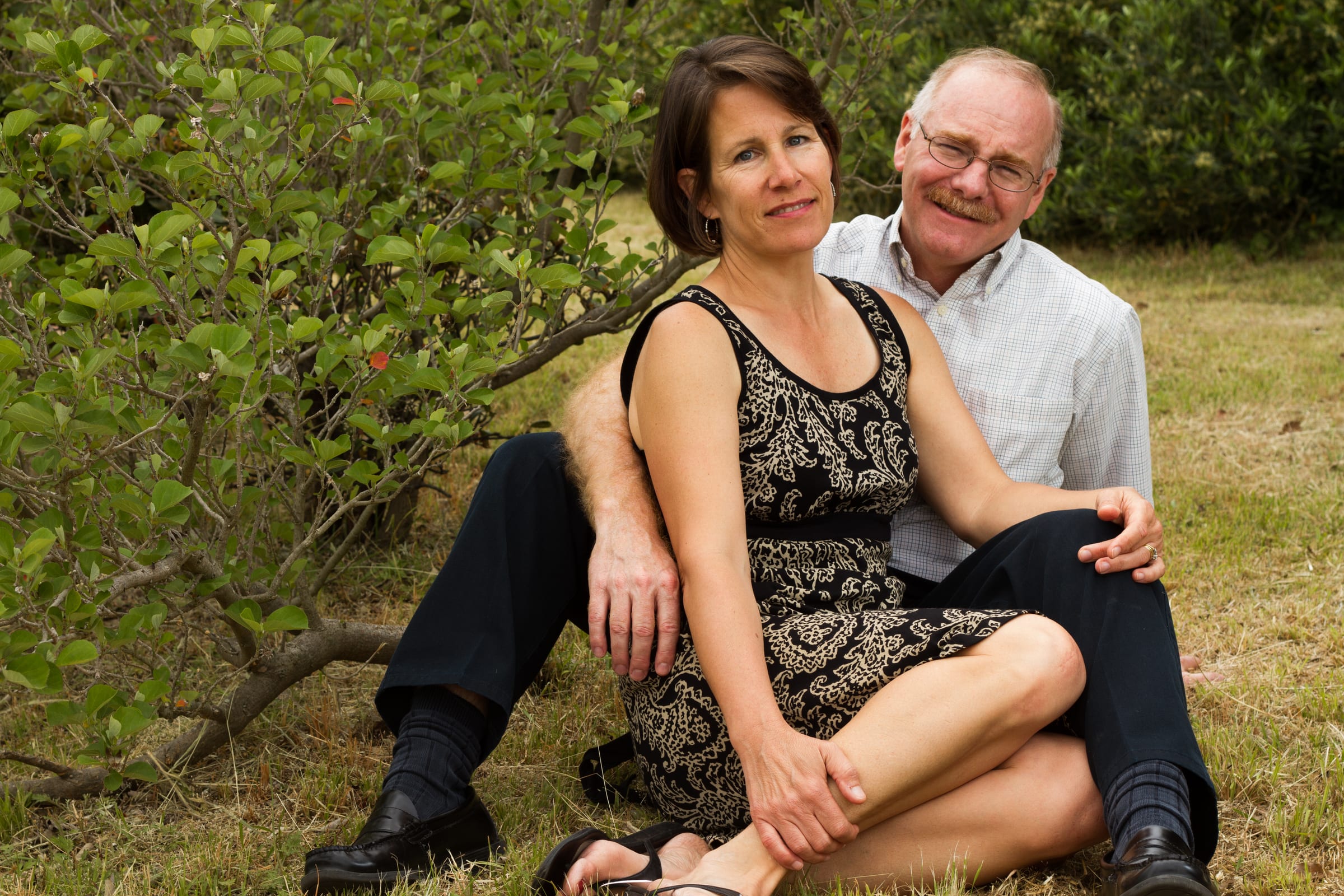 Couple seated together on grass in warm evening light