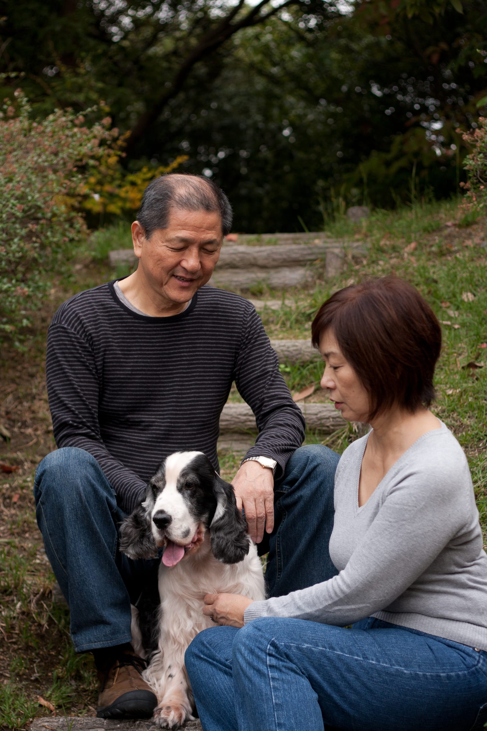 Couple seated outdoors with their dog in natural light
