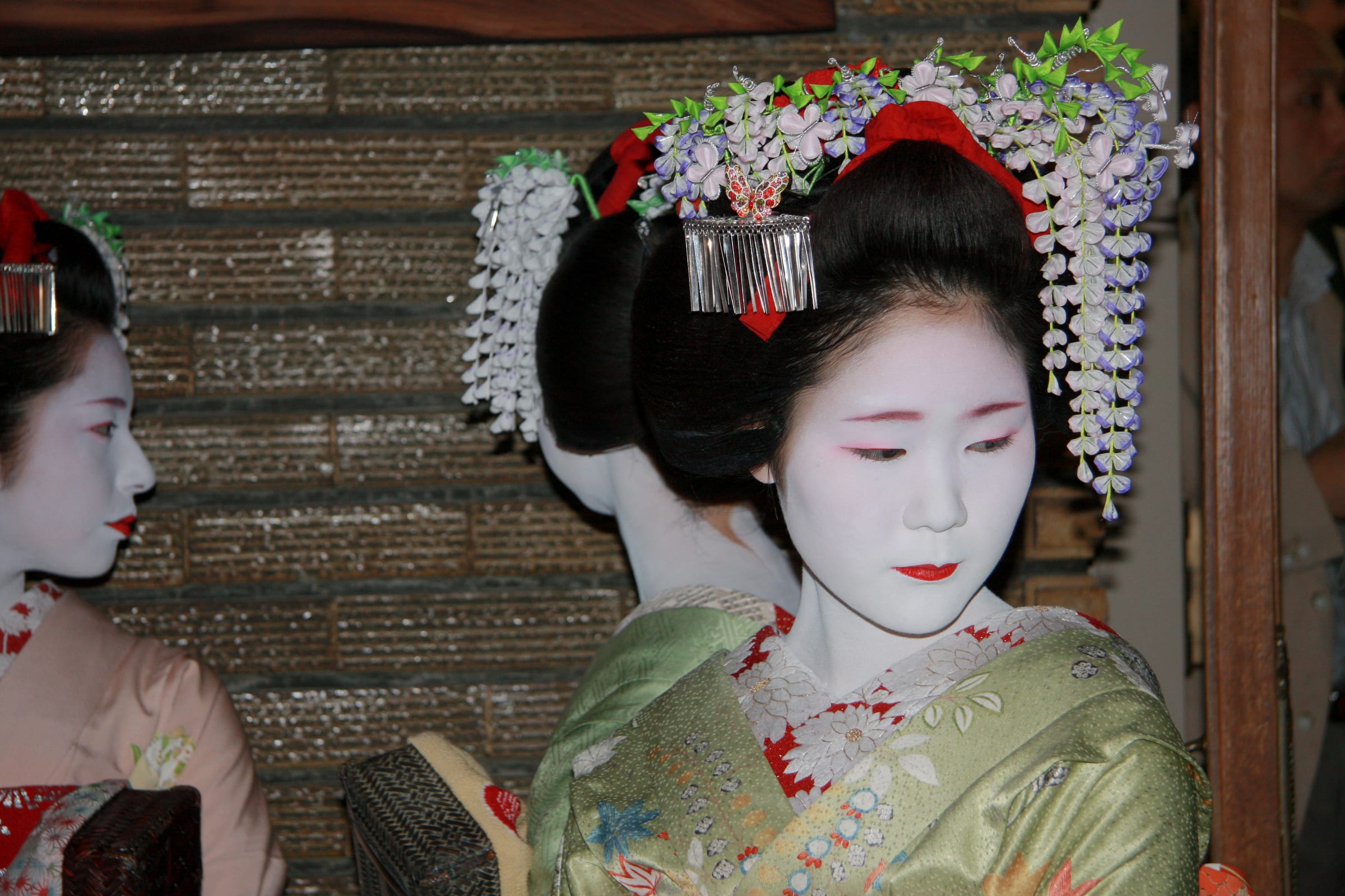 Portrait of a geisha in traditional attire illuminated by soft ambient light