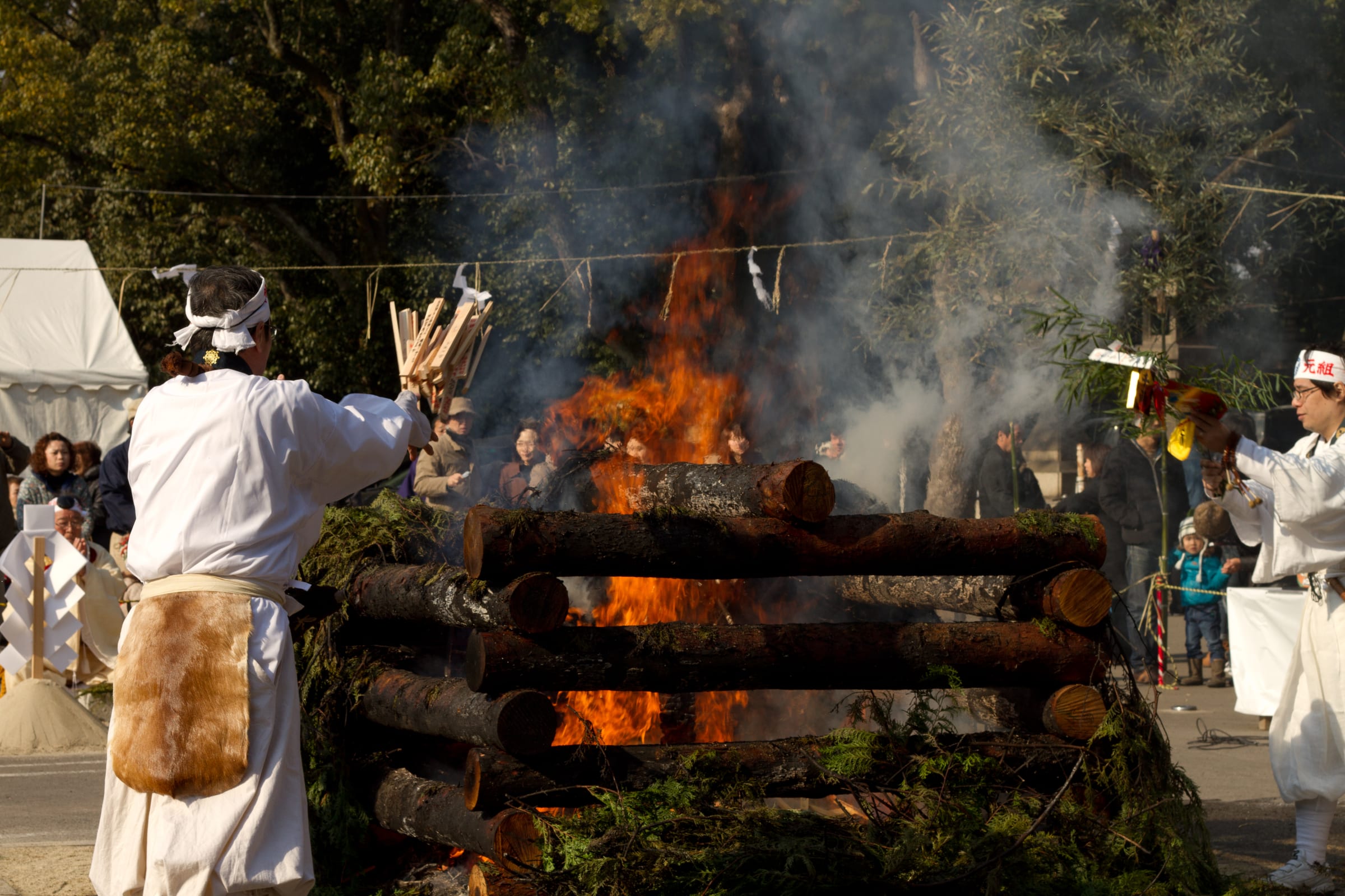Smoke and fire rising through a Japanese shrine during a ceremonial moment